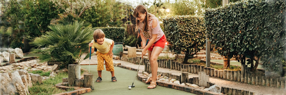 children playing miniature golf (stock photo)